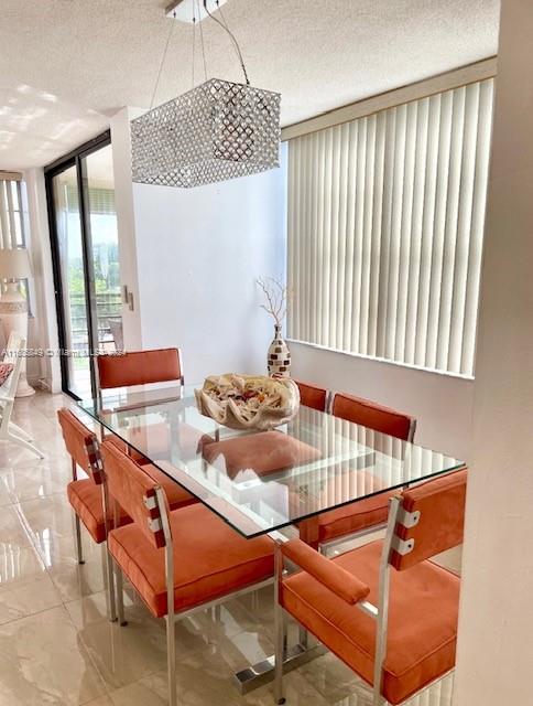 dining space featuring floor to ceiling windows and a textured ceiling