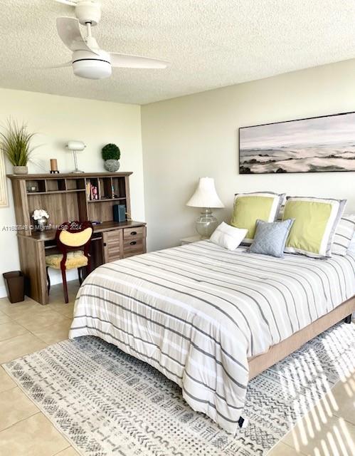 tiled bedroom featuring a textured ceiling and ceiling fan