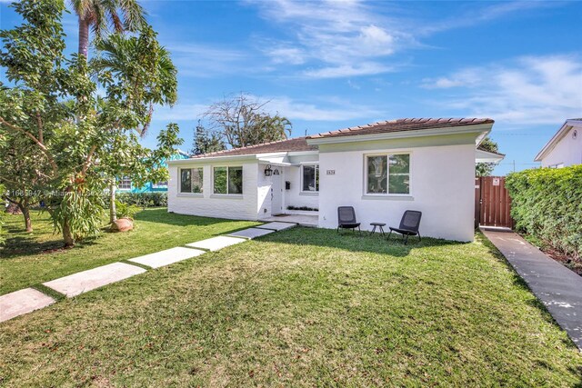 rear view of property featuring a yard