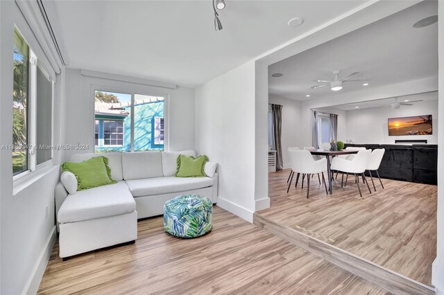 living room featuring light hardwood / wood-style flooring and ceiling fan