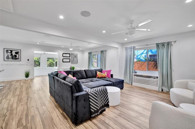 living room with ceiling fan, light wood-type flooring, and plenty of natural light