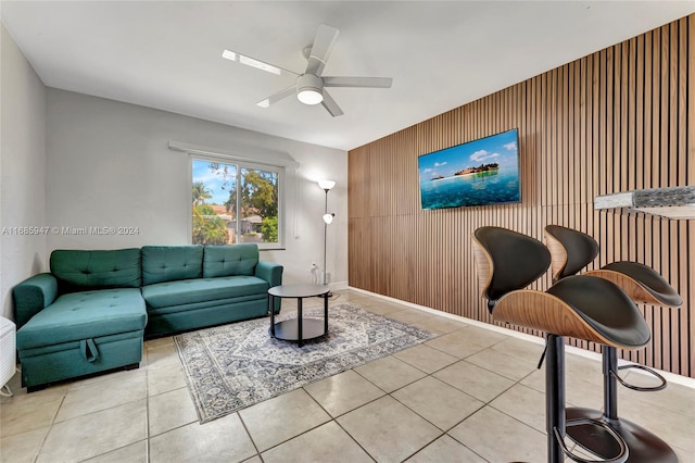 tiled living room with wooden walls and ceiling fan