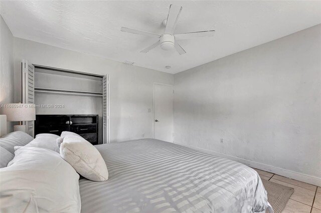 bedroom with a closet, ceiling fan, and light tile patterned floors