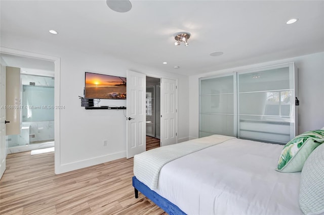 bedroom featuring light hardwood / wood-style flooring and ensuite bath