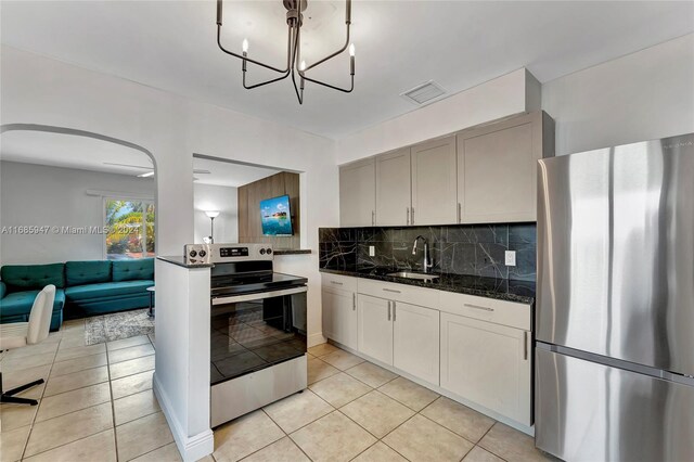 kitchen featuring tasteful backsplash, stainless steel appliances, sink, and light tile patterned floors