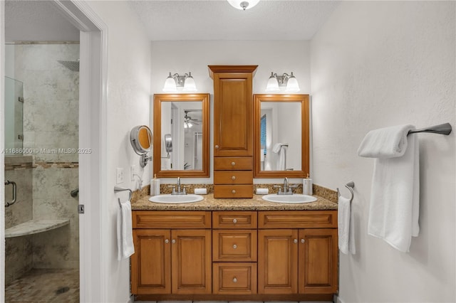 bathroom featuring an enclosed shower, vanity, and a textured ceiling