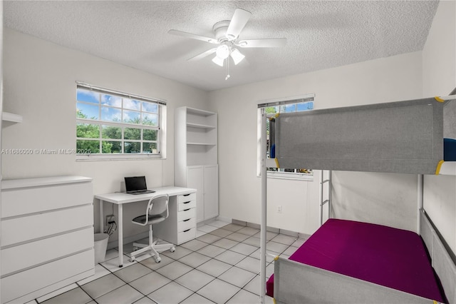 unfurnished bedroom featuring ceiling fan, a textured ceiling, and light tile patterned flooring