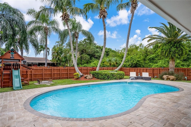 view of pool with a playground and a patio