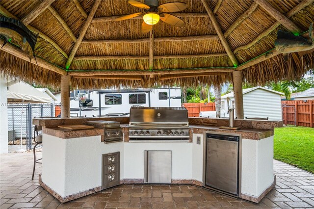 view of swimming pool featuring a patio area, an outdoor kitchen, a gazebo, a playground, and pool water feature