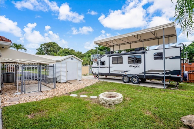 view of yard featuring a shed and an outdoor fire pit