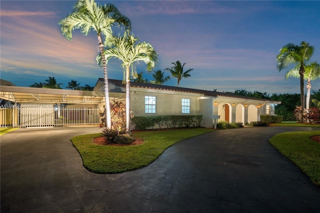 view of front of property featuring a carport and a lawn