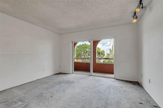 carpeted empty room with a textured ceiling