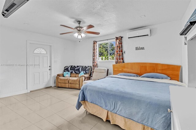 tiled bedroom with a wall mounted air conditioner, a textured ceiling, and ceiling fan