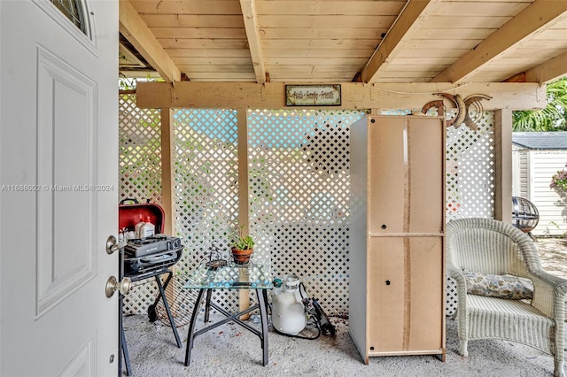 sunroom featuring beamed ceiling and wooden ceiling