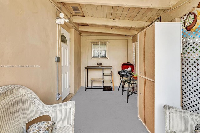 interior space featuring vaulted ceiling with beams and light colored carpet