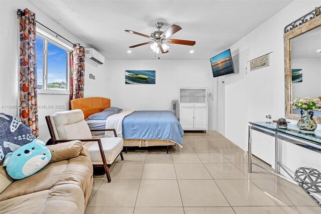 bedroom with ceiling fan, light tile patterned flooring, and a wall unit AC