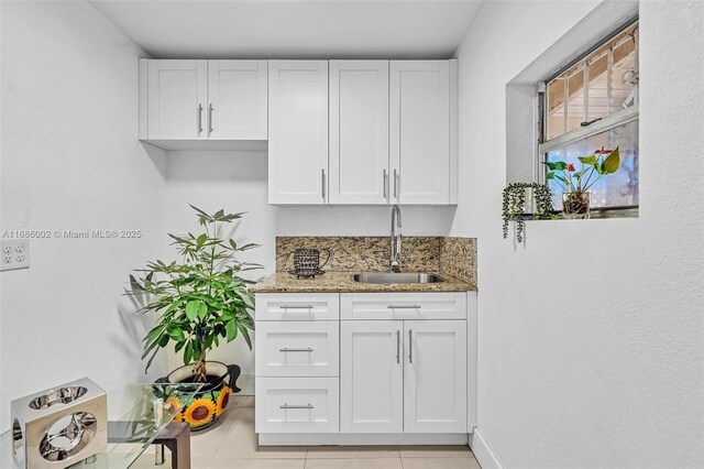 kitchen with sink, white cabinets, and light stone counters