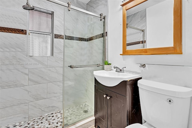 bathroom featuring vanity, toilet, and an enclosed shower