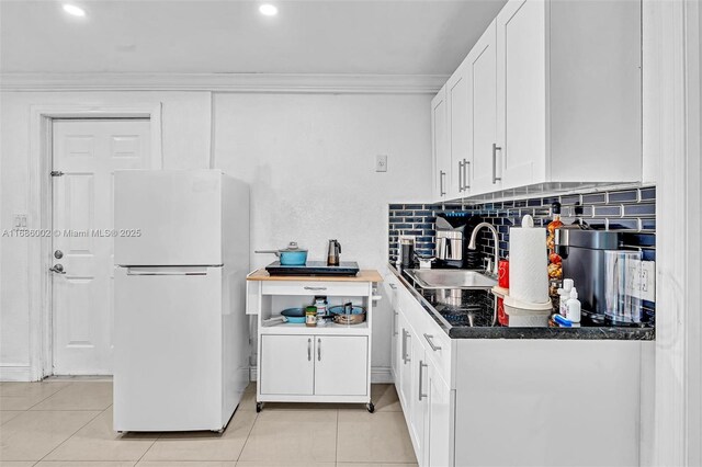 kitchen featuring white cabinetry, sink, vaulted ceiling, and white refrigerator