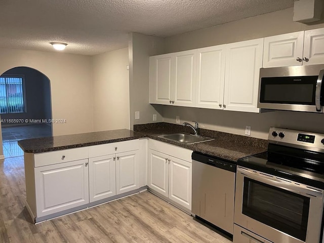 kitchen with sink, white cabinetry, kitchen peninsula, and stainless steel appliances