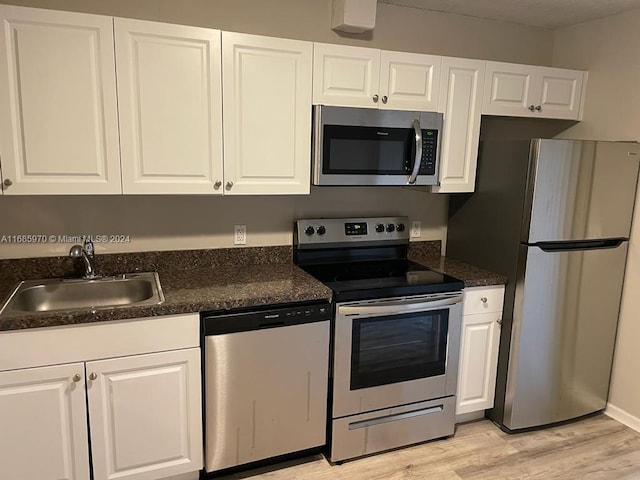 kitchen featuring light hardwood / wood-style floors, white cabinets, stainless steel appliances, and sink