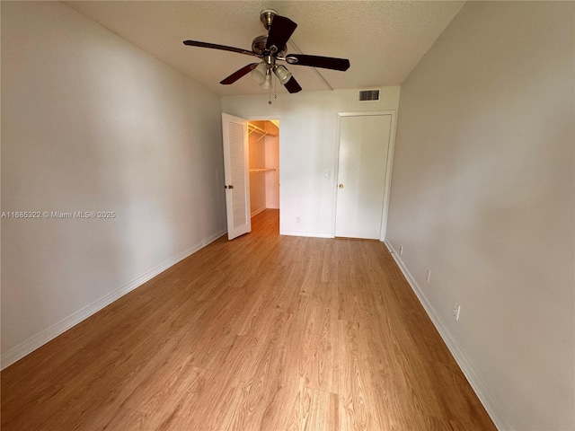 interior space featuring ceiling fan, a textured ceiling, and light hardwood / wood-style flooring