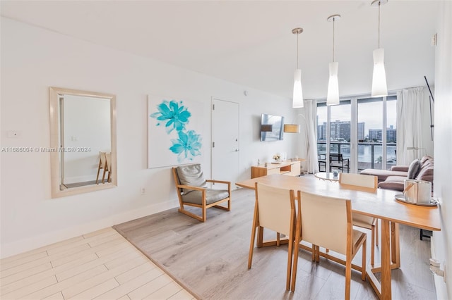 dining room with light wood-type flooring and a wall of windows