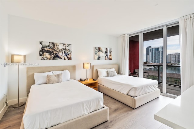 bedroom with access to outside and light hardwood / wood-style floors