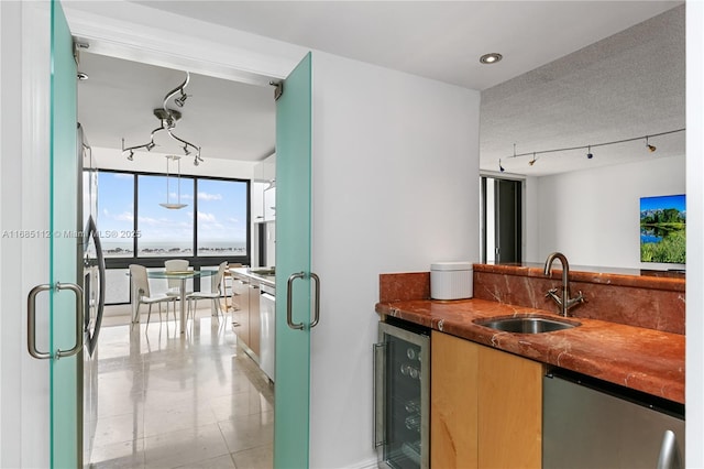 kitchen with a textured ceiling, beverage cooler, sink, refrigerator, and floor to ceiling windows