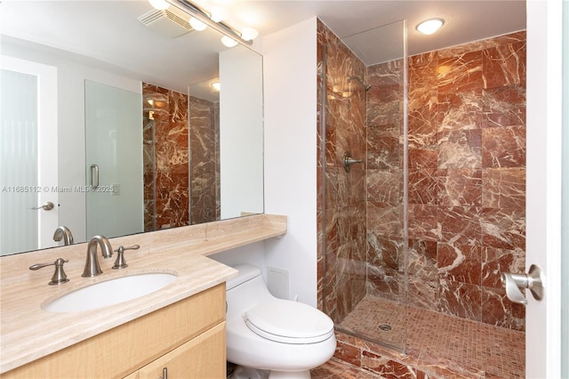 bathroom with toilet, tiled shower, and vanity