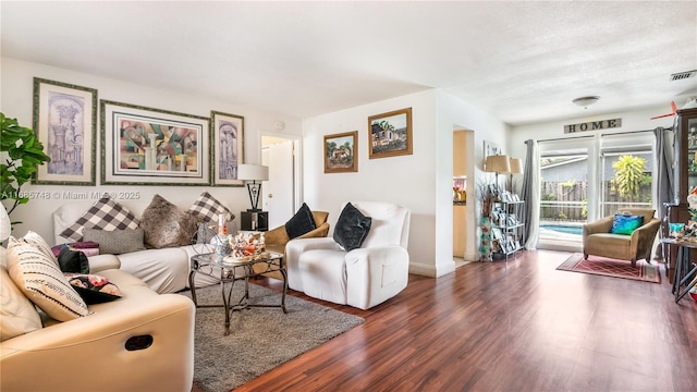 living room featuring a textured ceiling and dark hardwood / wood-style floors