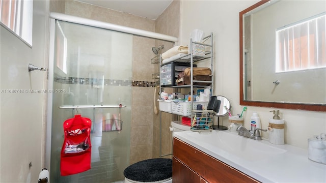 bathroom with vanity, toilet, and a shower with door