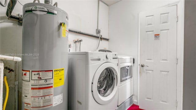 laundry area with washing machine and clothes dryer and water heater