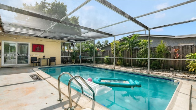 view of swimming pool featuring a patio and glass enclosure