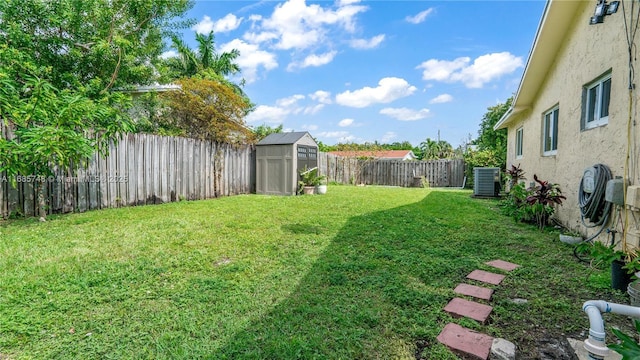 view of yard featuring a storage unit and central air condition unit