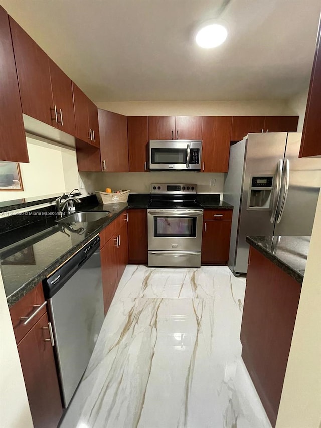 kitchen with stainless steel appliances, dark stone countertops, and sink