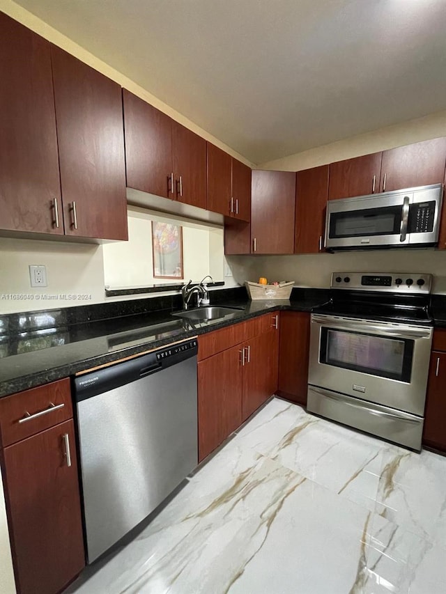 kitchen with dark stone countertops, sink, and appliances with stainless steel finishes