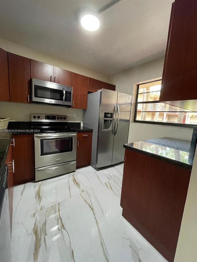 kitchen featuring dark stone countertops and appliances with stainless steel finishes