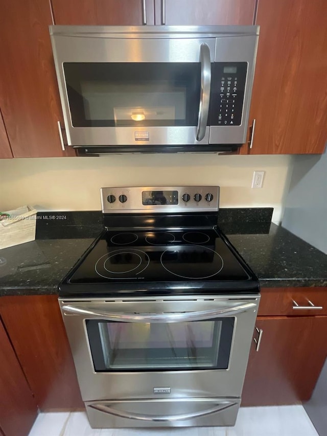 kitchen featuring stainless steel appliances and dark stone counters