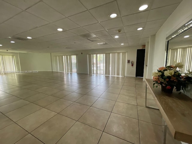 unfurnished room with light tile patterned flooring and a paneled ceiling