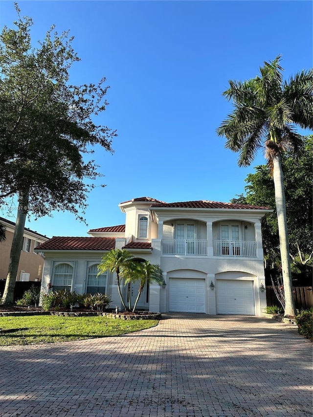 mediterranean / spanish-style house featuring a front yard and a garage