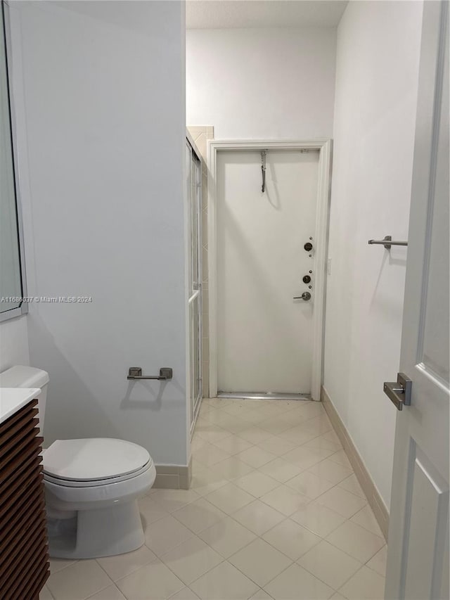 bathroom with tile patterned floors, vanity, toilet, and walk in shower