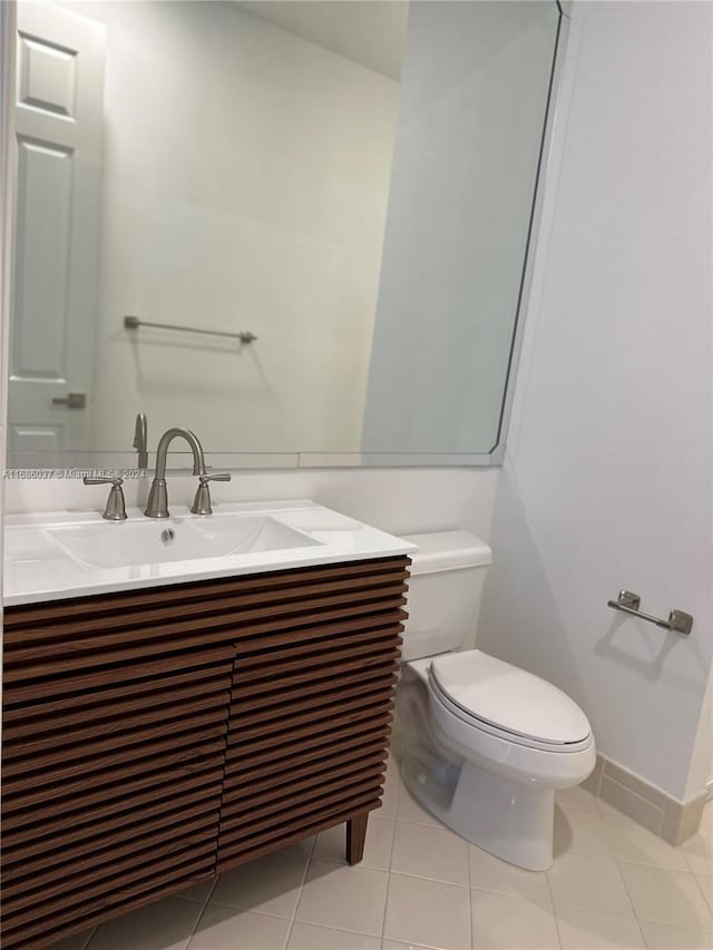 bathroom featuring tile patterned floors, vanity, and toilet