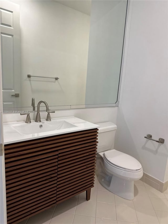 bathroom featuring tile patterned flooring, vanity, and toilet