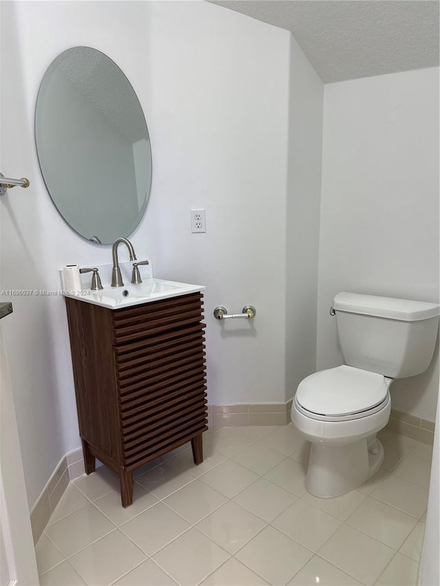 bathroom featuring tile patterned floors, vanity, a textured ceiling, and toilet