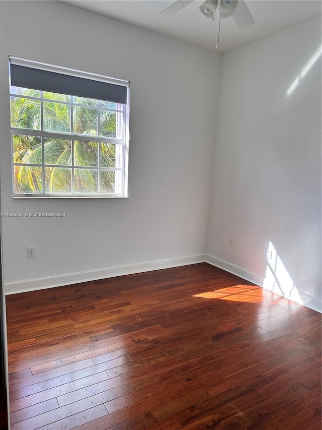 empty room featuring dark hardwood / wood-style flooring and ceiling fan