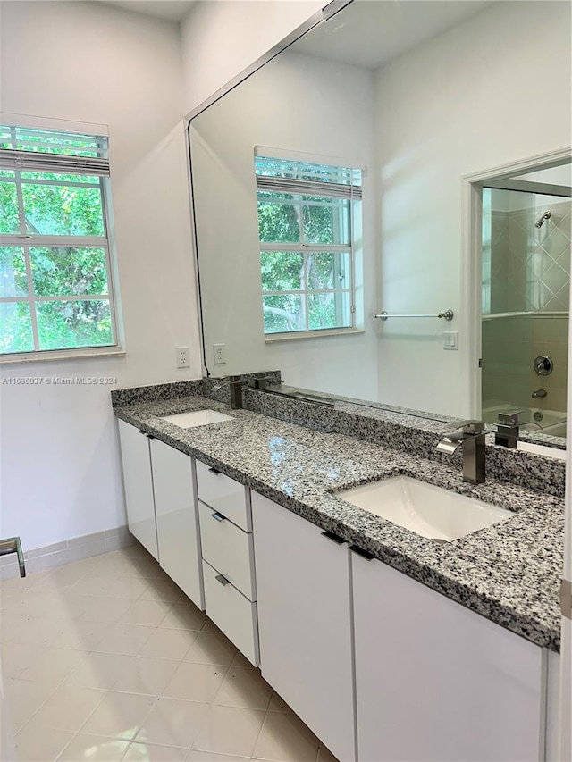 bathroom featuring vanity, tiled shower / bath combo, and tile patterned flooring