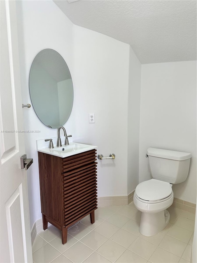 bathroom with vanity, tile patterned floors, a textured ceiling, and toilet