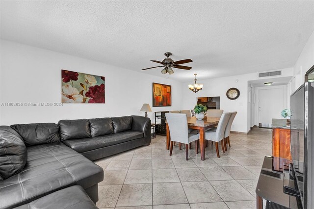 living room featuring a textured ceiling, light tile patterned floors, and ceiling fan