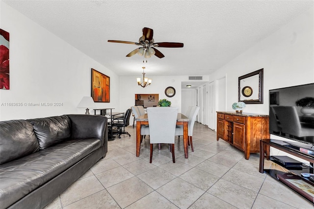 tiled dining space with a textured ceiling and ceiling fan with notable chandelier